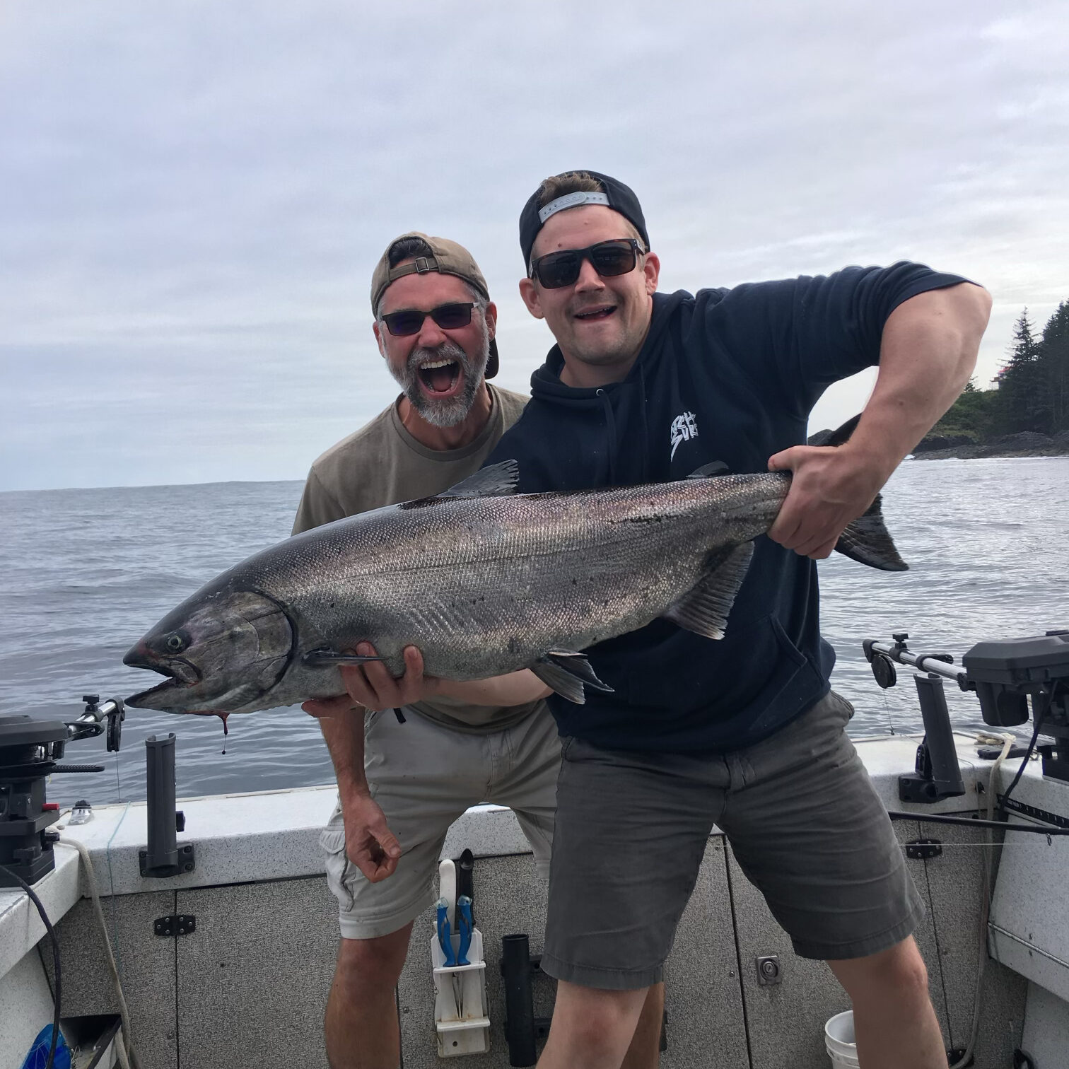 Two men with a chinook salmon